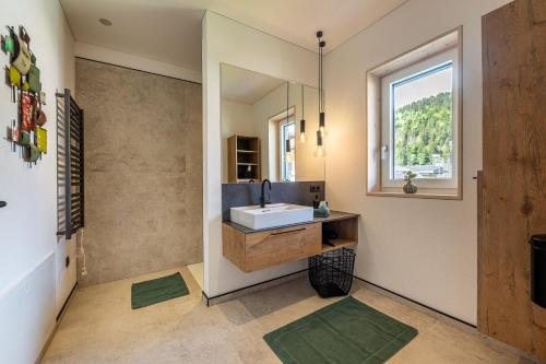 a bathroom with a sink and a mirror at Glückhoch2 in Hochfilzen