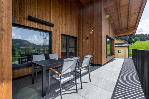 an outdoor patio with a black table and chairs at Glückhoch2 in Hochfilzen