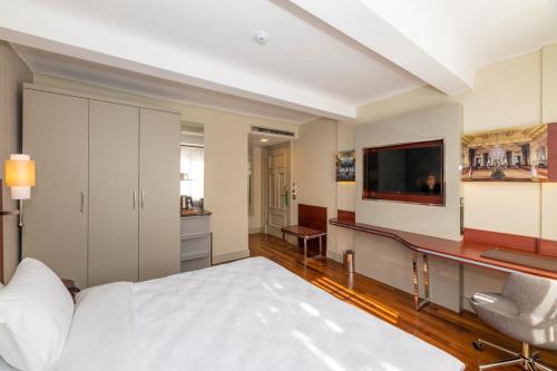 a bedroom with a bed and a flat screen tv at Blue Gilroy Hotel in Istanbul