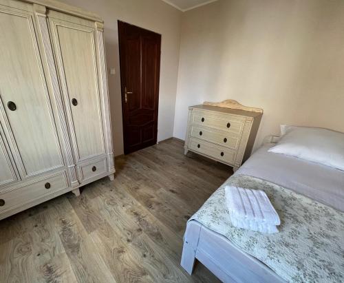 a bedroom with a bed and a dresser and a cabinet at Cozy apartment close to Gdansk & Airport in Gdańsk
