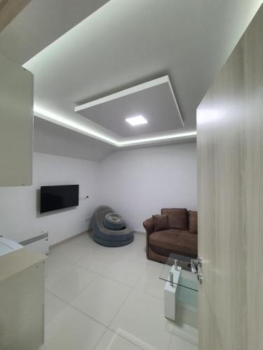 Una sala de estar con un sofá y un televisor. en Apartman Tolosi 2, en Podgorica