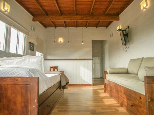 a bedroom with a bed and a couch at El Diablo y el Mar in Punta Del Diablo