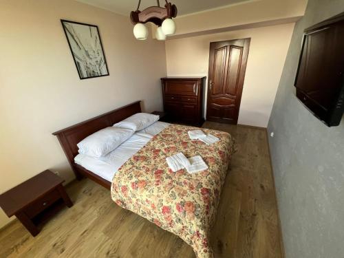 a small bedroom with a bed with a floral bedspread at Cozy apartment close to Gdansk & Airport in Gdańsk
