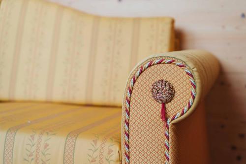 a chair with a hat on top of a bed at Wanderhotel Teiserhof in Funes