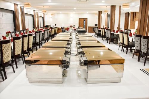 une grande salle à manger avec des tables et des chaises dans l'établissement Hotel Platinum Shravasti, à Katra
