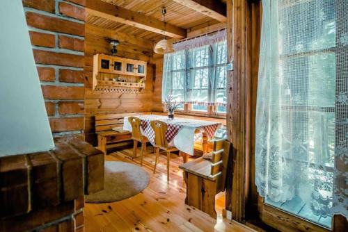 - une salle à manger avec une table dans une cabane en rondins dans l'établissement In The Woods - Chata w lesie na wyłączność, à Supraśl