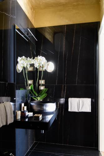 a bathroom with a black tiled wall at Tornabuoni Suites Collection Residenza D'Epoca in Florence