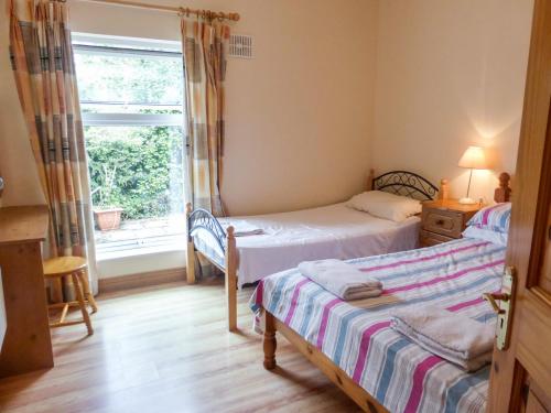 um quarto com 2 camas e uma janela em Borahard Lodge em Newbridge