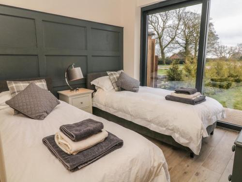 two beds with towels on top of them in a bedroom at Saddlers in Stone