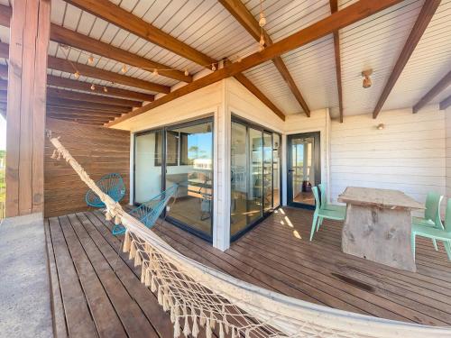 a porch with a hammock on a house at El Diablo y el Mar in Punta Del Diablo