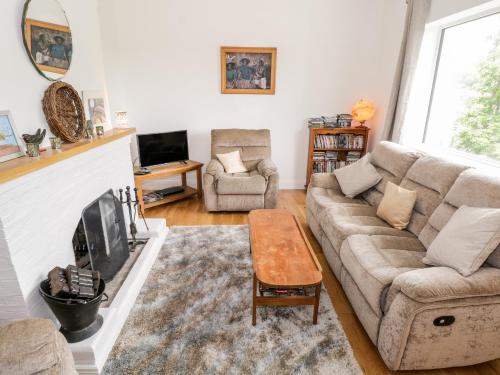 a living room with a couch and a tv at Rainbows End in Clifden