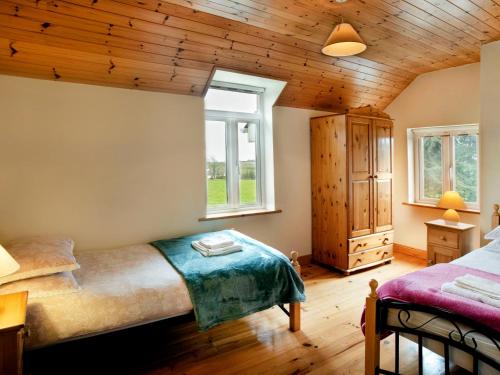 a bedroom with a bed and two windows at Glen Gable in Fethard on Sea