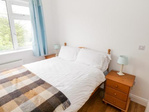 a bedroom with a bed and a window at Rainbows End in Clifden