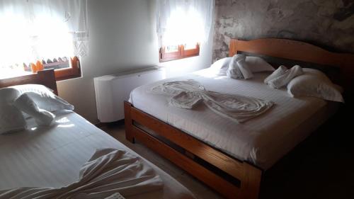 a bedroom with a bed with a dress on it at Bujtina Te Xhako in Përmet