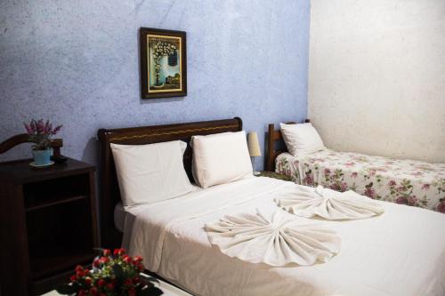 a bedroom with two beds with white sheets at Pousada Adega Cipo in Serra do Cipo