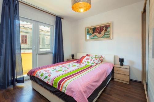 a bedroom with a bed and a window at Sunny apartment ILI near Amfiteatar in Pula