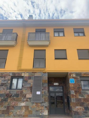 a yellow building with a door and a balcony at Dinoapartamento in Teruel