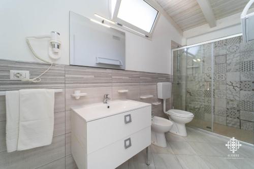Baño blanco con lavabo y aseo en Borgo Marino Beach Residence en Lampedusa