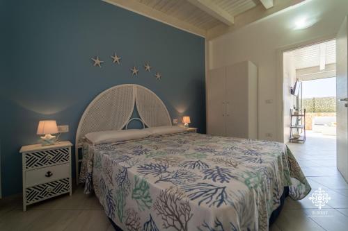 Borgo Marino Beach Residence في لامبيدوسا: غرفة نوم بسرير وجدار ازرق