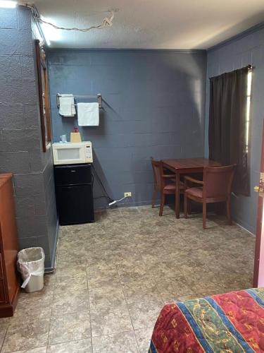 a room with a table and a kitchen and a table and chairs at Budget Inn in Mineola