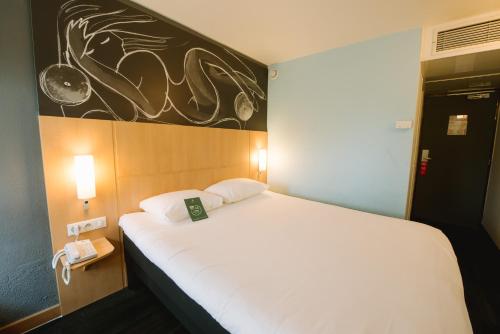 a bedroom with a white bed with a sign on it at ibis Avignon Centre Gare in Avignon