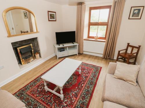 a living room with a couch and a table and a tv at Brynawel in Carmarthen