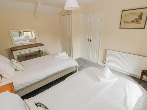 two beds in a small room with a mirror at Brynawel in Carmarthen