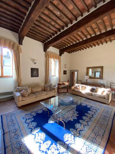 a large living room with a large blue rug at Hotel Palazzo Squarcialupi in Castellina in Chianti