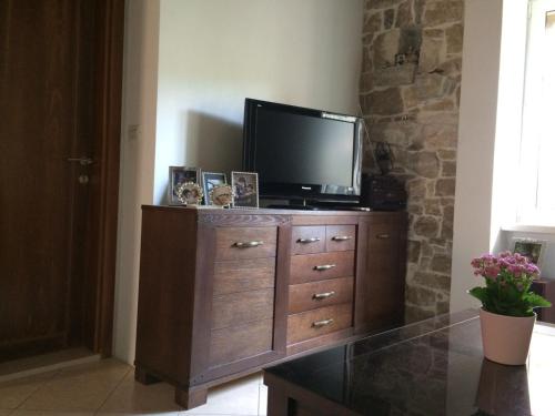 a television on top of a wooden dresser in a room at Apartman Lana Beachfront in Sumpetar