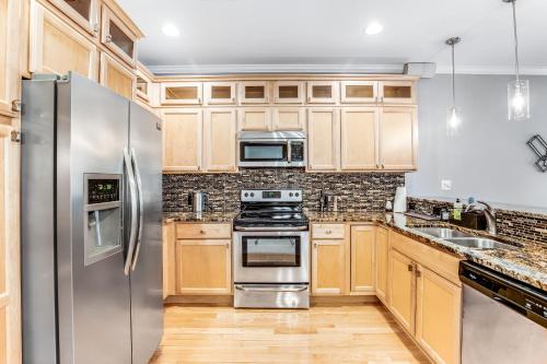 a kitchen with wooden cabinets and stainless steel appliances at Oyster Bay Villas --- 20411 Jeb Dr Unit #37 in Rehoboth Beach