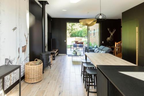 Il comprend une cuisine avec une table et des chaises ainsi qu'un salon. dans l'établissement Aux Bois Dorés de la Ferme de sorval, animaux de la ferme, fitness, à Selvigny