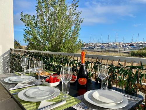 a table with glasses and a bottle of wine at Blue Sky apartment Marina in Lagos