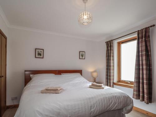 sypialnia z łóżkiem z dwoma ręcznikami w obiekcie Boatman's Cottage w mieście Coillemore
