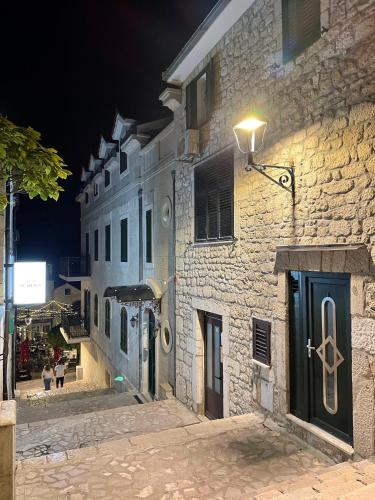 um edifício de pedra com uma rua à noite em Main Square Studio 1 em Imotski