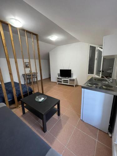 um quarto com uma cozinha e uma sala de estar com uma mesa em Main Square Studio 1 em Imotski