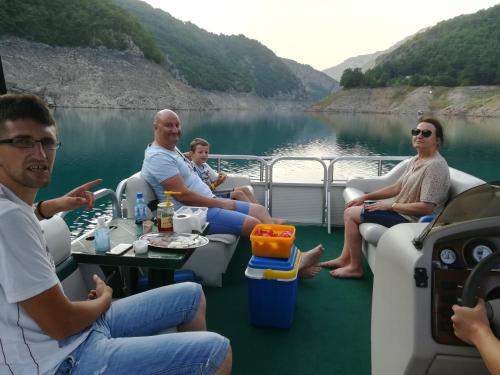 um grupo de pessoas sentadas na parte de trás de um barco em dvokrevetni apartman em Pluzine