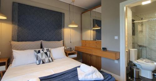 sypialnia z łóżkiem, umywalką i lustrem w obiekcie Malamas Apartment w Kalamácie