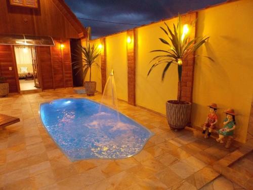 a large tub in a room with two figurines next to it at Chalé Paraíso com piscina privativa em Brotas SP in Brotas