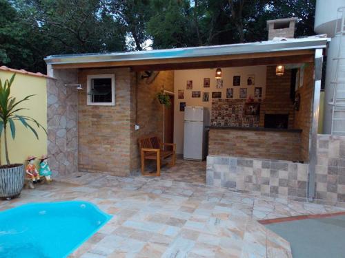 a building with a kitchen and a swimming pool at Chalé Paraíso com piscina privativa em Brotas SP in Brotas