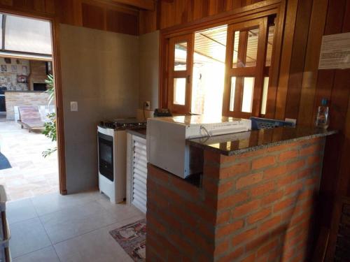 a kitchen with a stove and a counter top at Chalé Paraíso com piscina privativa em Brotas SP in Brotas