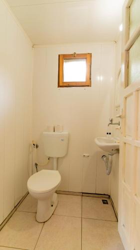 a white bathroom with a toilet and a sink at Turkmen Tree Houses in Olympos