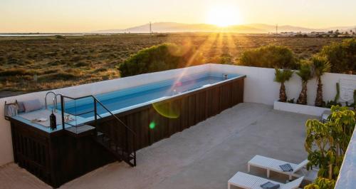 bañera de hidromasaje en un balcón con vistas a la puesta de sol en el desierto en Exclusivo cortijo con piscina privada, en Almería