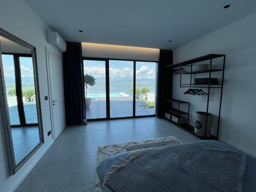 a bedroom with a bed and a view of the ocean at Lake Breeze Villa with a Pool & Magnificent Views in Shirokë