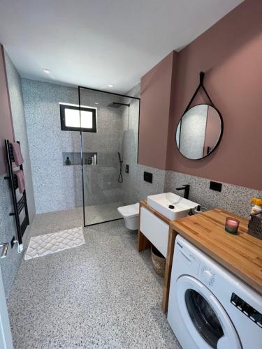 a bathroom with a washing machine and a sink at Lake Breeze Villa with a Pool & Magnificent Views in Široka