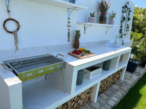 a kitchen with a grill and fruit on a cutting board at Lake Breeze Villa with a Pool & Magnificent Views in Široka