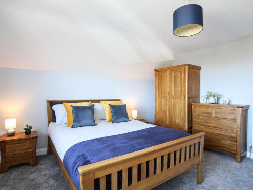 a bedroom with a large bed and a wooden cabinet at The Elberry in Llanfairpwllgwyngyll