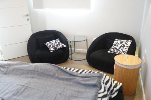two black chairs in a room with a bed at Cancun in Netanya