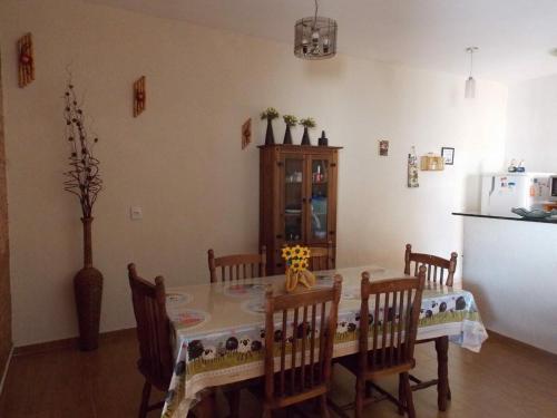 a dining room with a table and chairs and a kitchen at Cantinho rústico com piscina privativa em Brotas SP in Brotas
