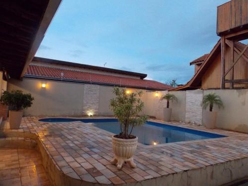 a potted tree in a pot next to a swimming pool at Cantinho rústico com piscina privativa em Brotas SP in Brotas
