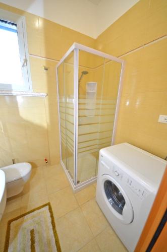 a washing machine in a bathroom with a toilet at VillettaPuce in Corsano